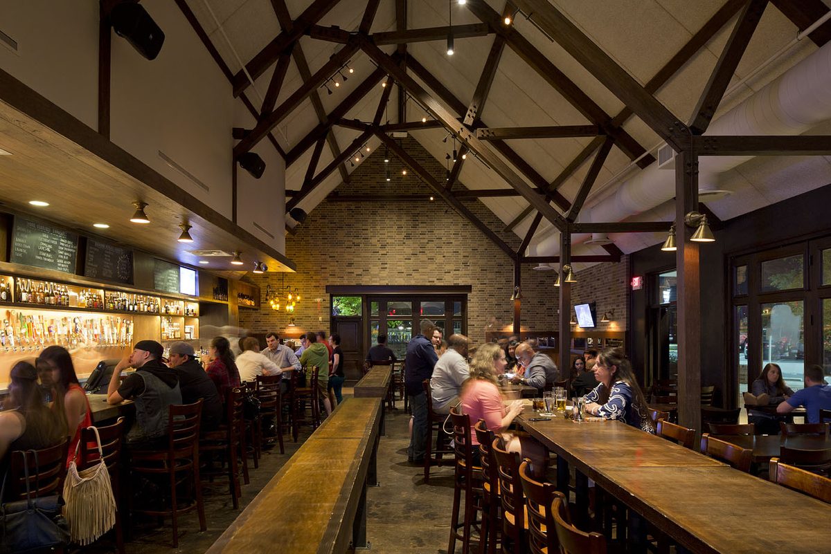 The main room in the evening, busy along the bar and communal tables.