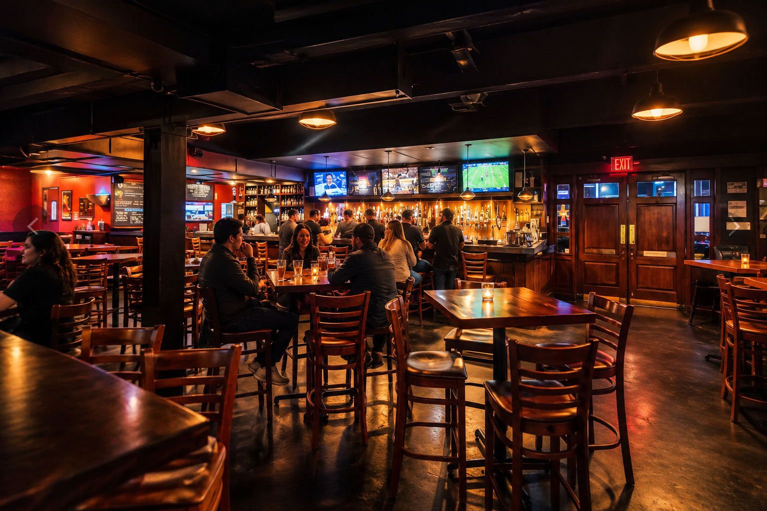 The bar in the evening, guests at tables under warm pendant lighting.